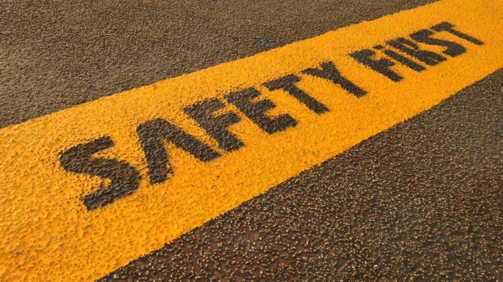 Safety first written in yellow paint on the road